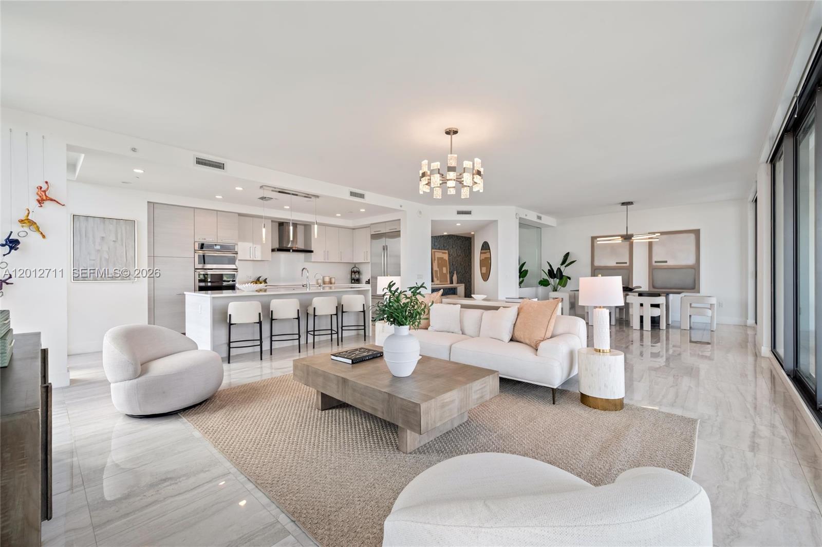 A modern open-concept living room and kitchen featuring light wood cabinetry and marble flooring — 100 E Las Olas Blvd # 3201, Fort Lauderdale FL 33301, FORT LAUDERDALE, FL