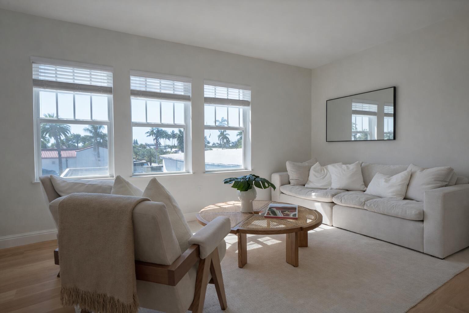 A bright living room features a white sofa, a round rattan coffee table, and three windows — 184 Sunset Avenue # 303, Palm Beach FL 33480, PALM BEACH, FL