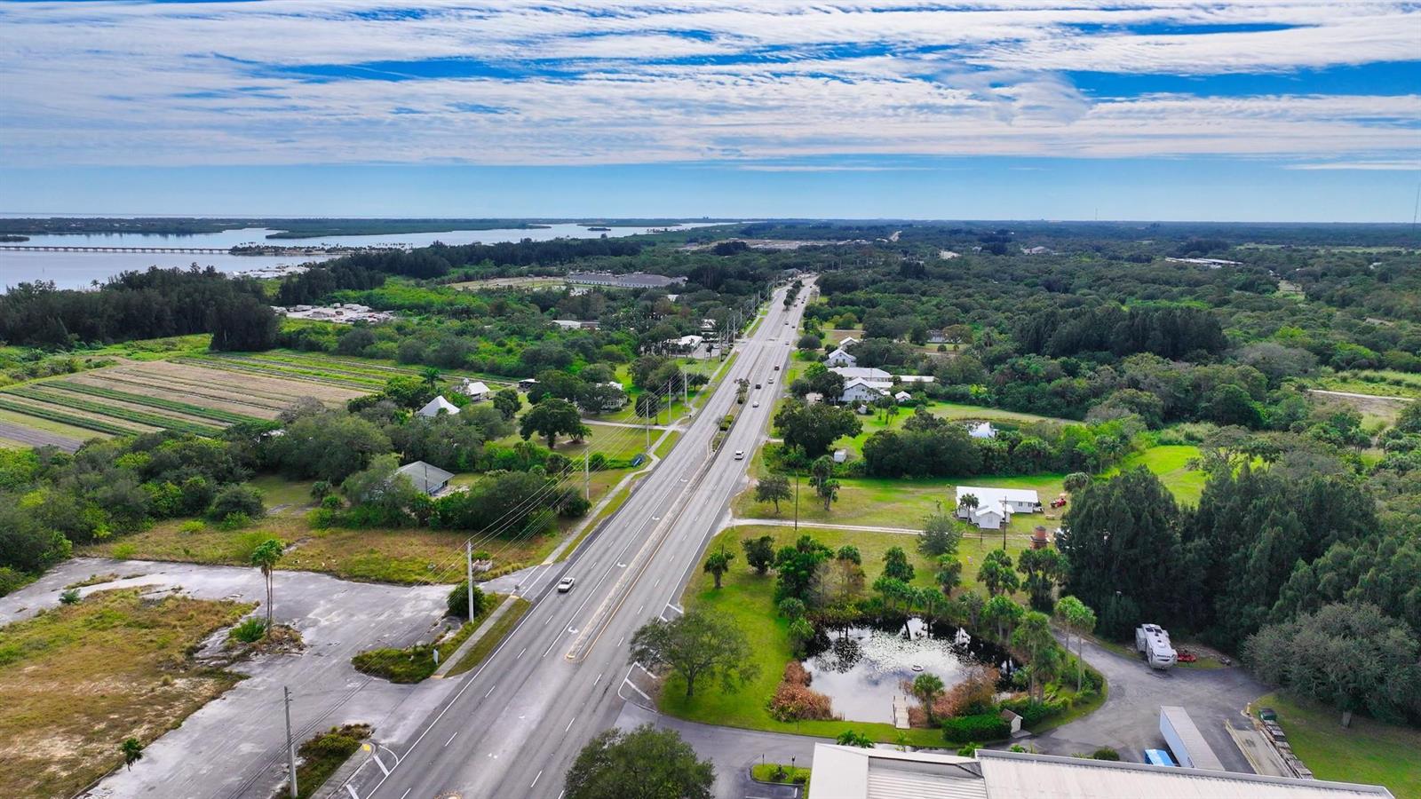 An aerial view shows a highway running through a rural landscape with trees and water — 9185 US Highway 1, Sebastian FL 32958, SEBASTIAN, FL