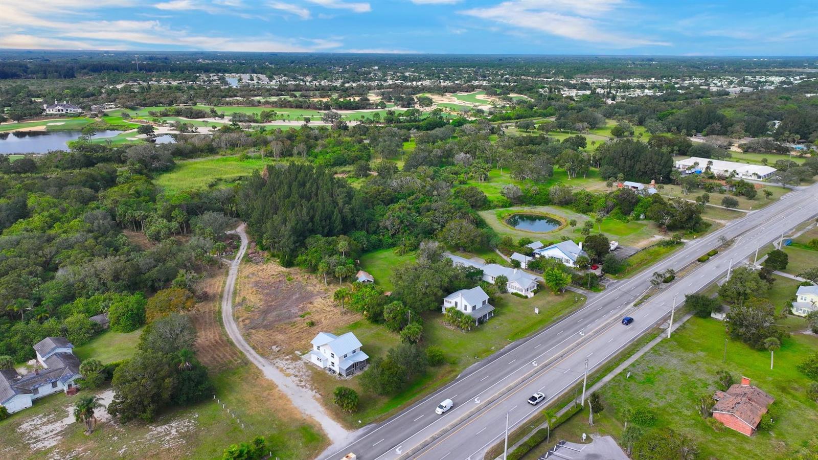 An aerial view shows several houses situated along a multi-lane road near a golf course — 9185 US Highway 1, Sebastian FL 32958, SEBASTIAN, FL