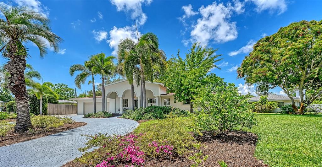 A single-story house with a paved driveway, palm trees, and a landscaped front yard — 2465 FOSTER LANE, SARASOTA, FL