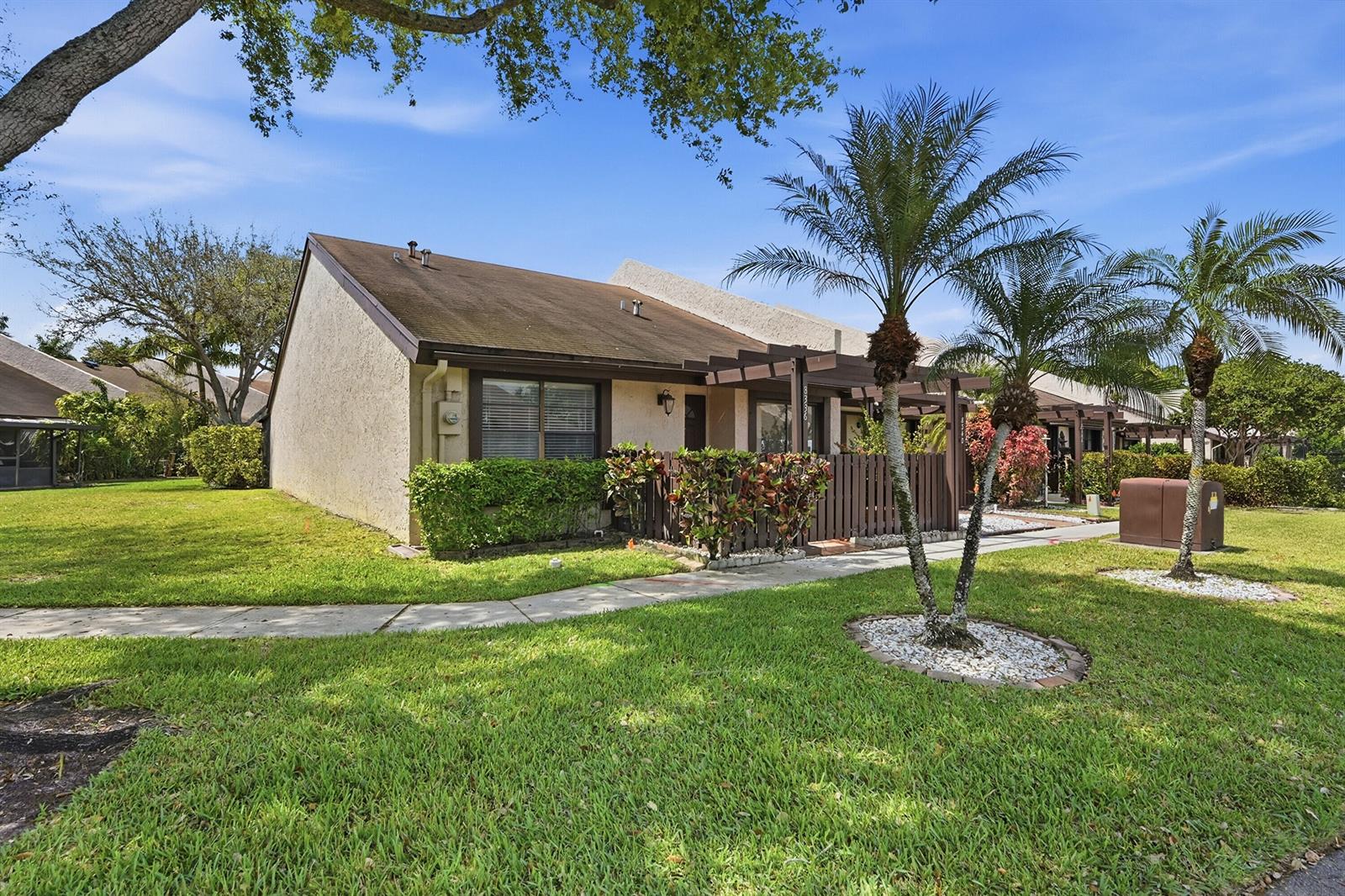 A single-story townhouse with a brown roof, stucco exterior, and a small wooden front patio — 8336 NW 37th Place, Sunrise FL 33351, SUNRISE, FL
