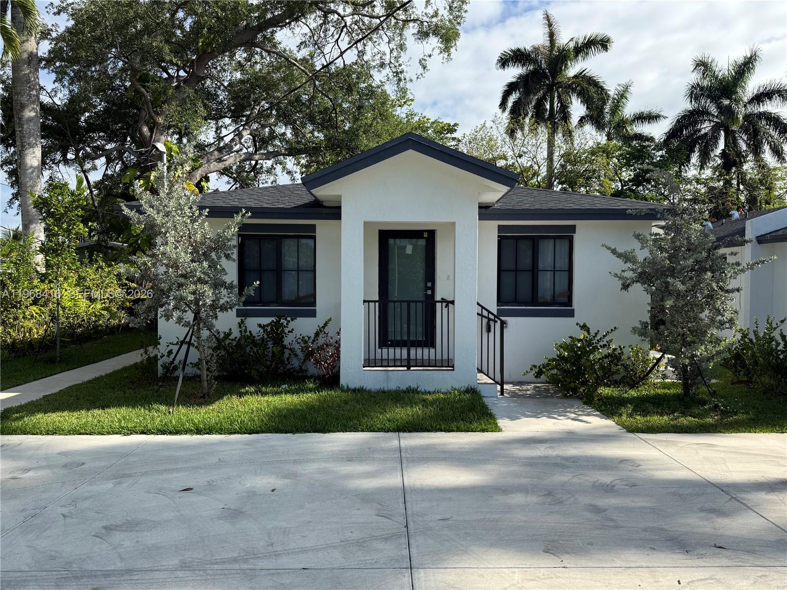 A small, white, single-story house with a dark roof and a central covered entryway — 210 SW 3rd St, Florida City FL 33034, FLORIDA CITY, FL