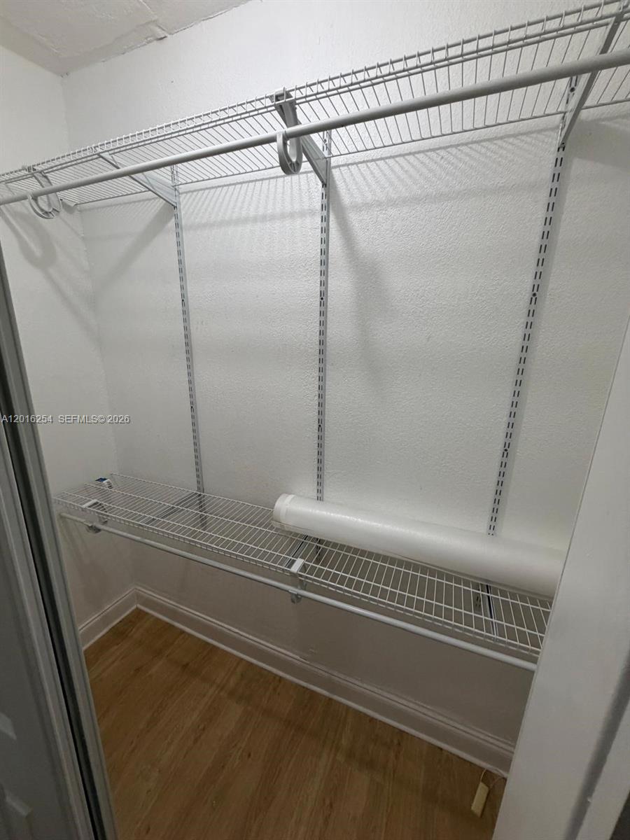 A walk-in closet features white wire shelving and light wood-look flooring — 9050 NW 31st Ave # 2, Miami FL 33147, MIAMI, FL