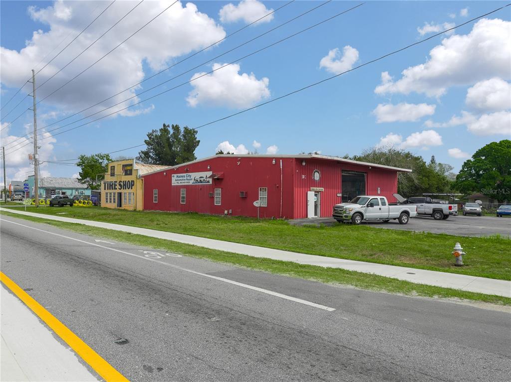 A red automotive repair shop and an adjacent yellow tire shop sit along a road — 301 US HIGHWAY 17 92 N, HAINES CITY, FL