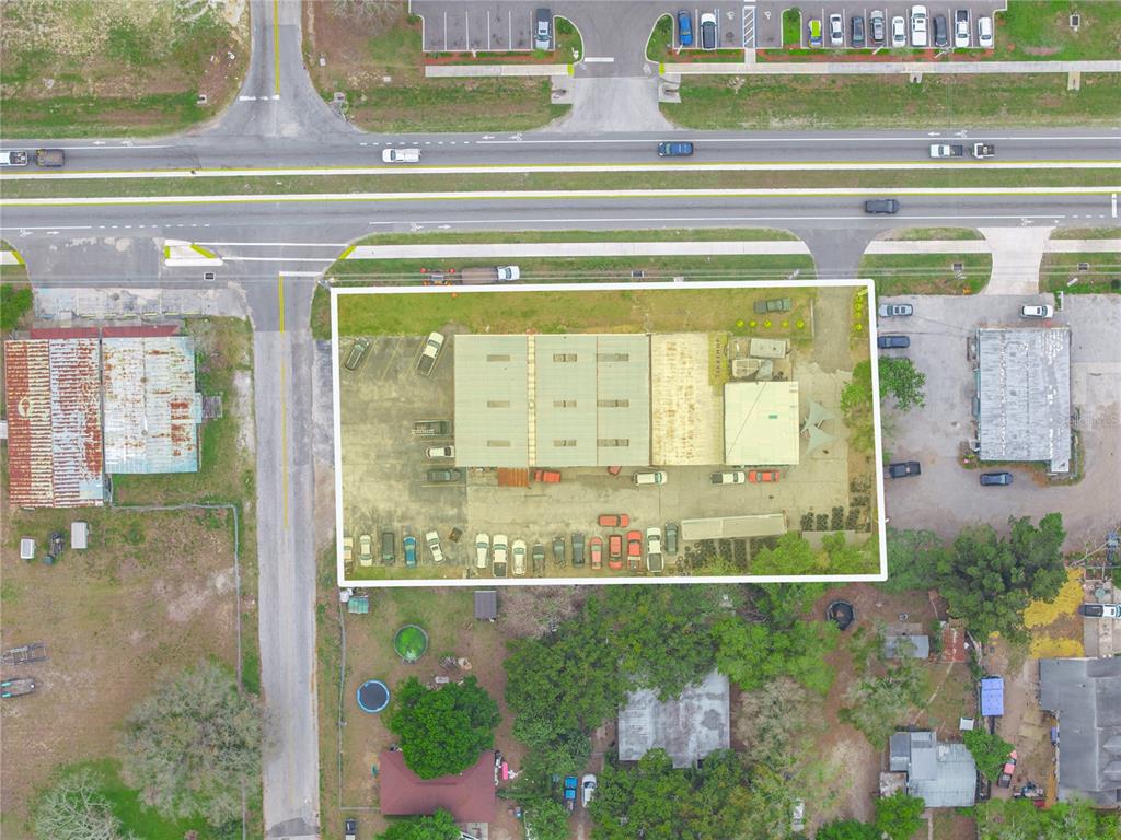 This aerial view shows a commercial property with a warehouse building and parking lot — 301 US HIGHWAY 17 92 N, HAINES CITY, FL