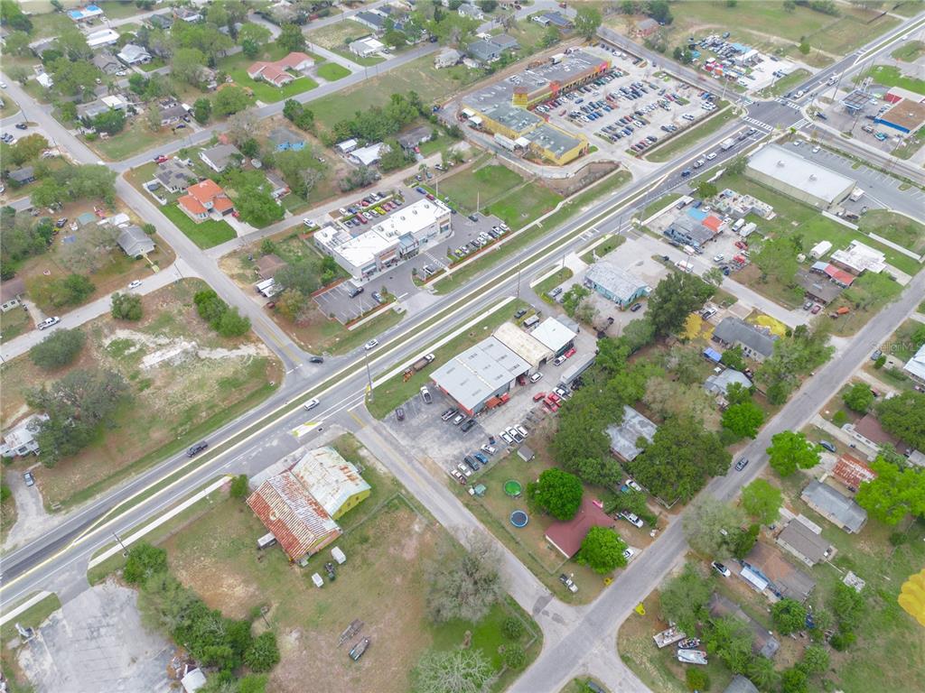 An aerial view shows a commercial area with buildings, parking lots, and surrounding residential streets — 301 US HIGHWAY 17 92 N, HAINES CITY, FL