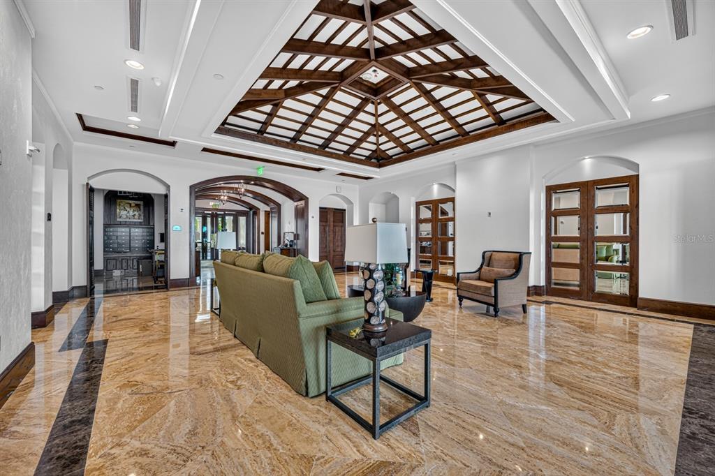 A spacious lobby features a coffered wood ceiling, polished marble floors, and a green sofa — 85 AVENUE DE LA MER UNIT 502, PALM COAST, FL