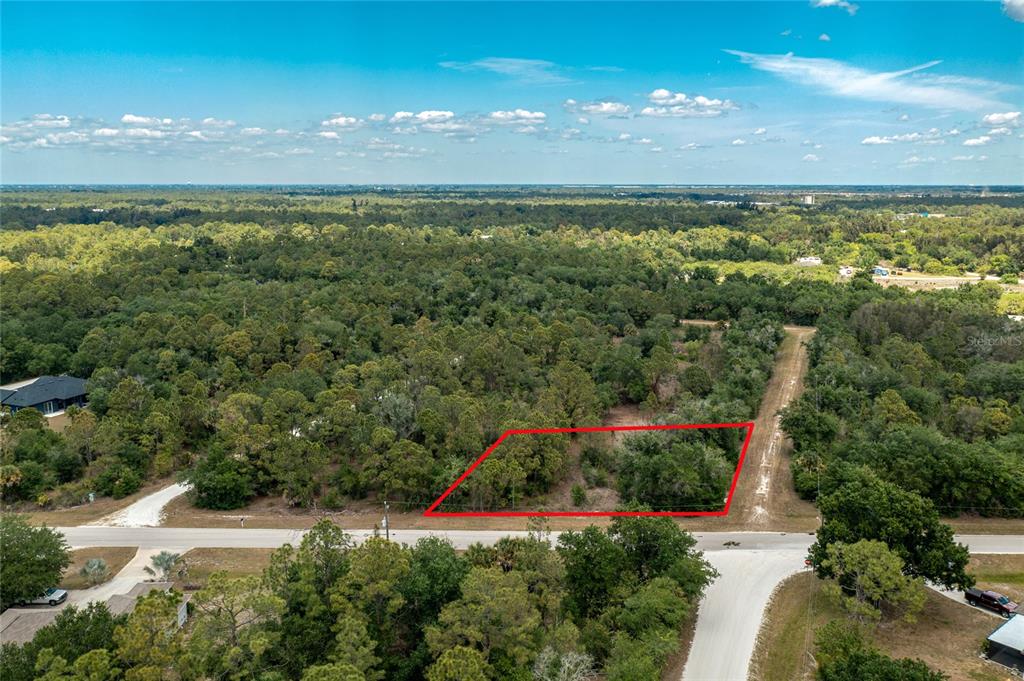 An aerial view shows a rectangular, wooded vacant lot outlined in red along a road — 28250 MORNINGSIDE DRIVE, PUNTA GORDA, FL