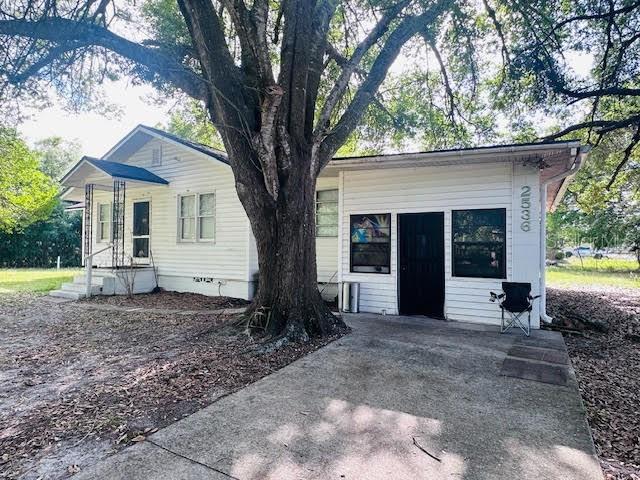 A white, single-story house with a large tree in the front yard and a driveway — 2536 MAGNOLIA AVENUE, SANFORD, FL