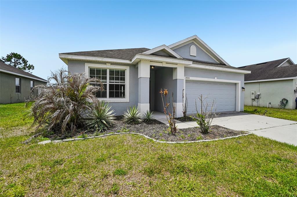 A single-story gray house with a two-car garage and a small front garden — 14310-a ALISTAR MANOR, WIMAUMA, FL