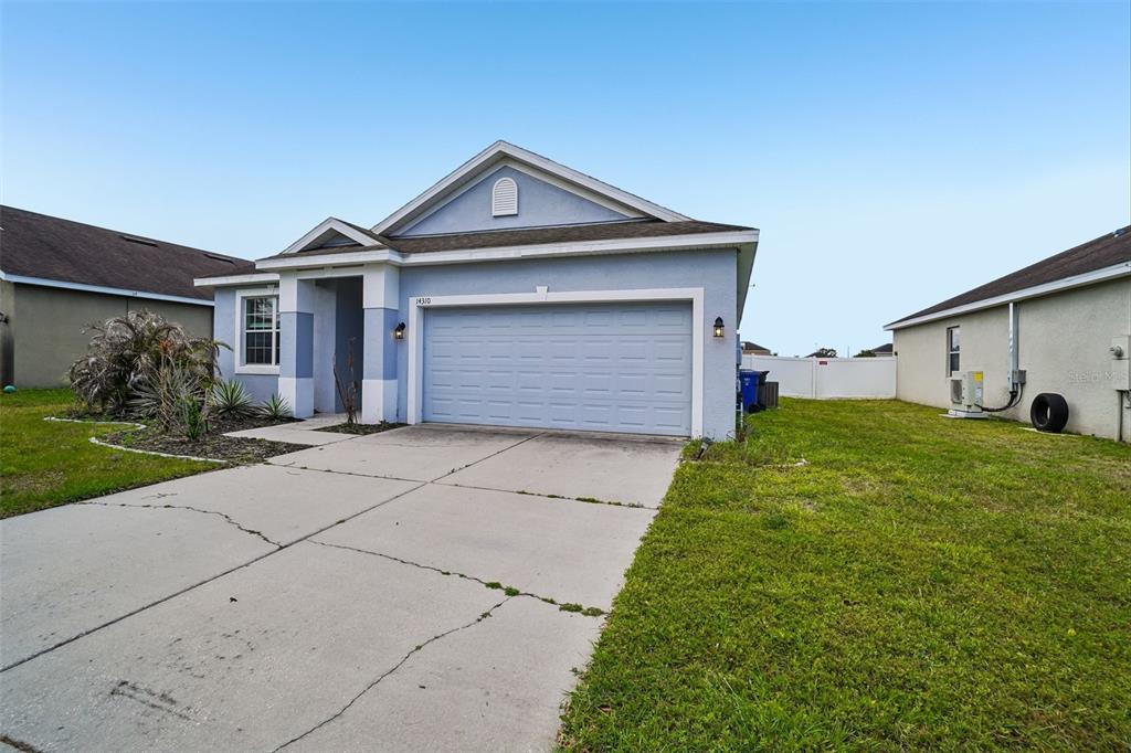 A light blue single-story house with a two-car garage and a concrete driveway — 14310-a ALISTAR MANOR, WIMAUMA, FL