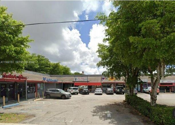 A low-rise commercial strip mall with a parking lot in front under a cloudy sky — 4685 NW 7th St, Miami FL 33126, MIAMI, FL