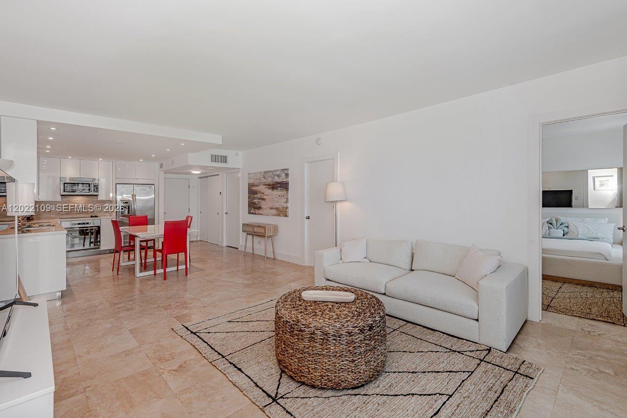 An open-concept living and dining area features white walls, tile floors, and modern furniture — 2301 Collins Ave # 1515, Miami Beach FL 33139, MIAMI BEACH, FL