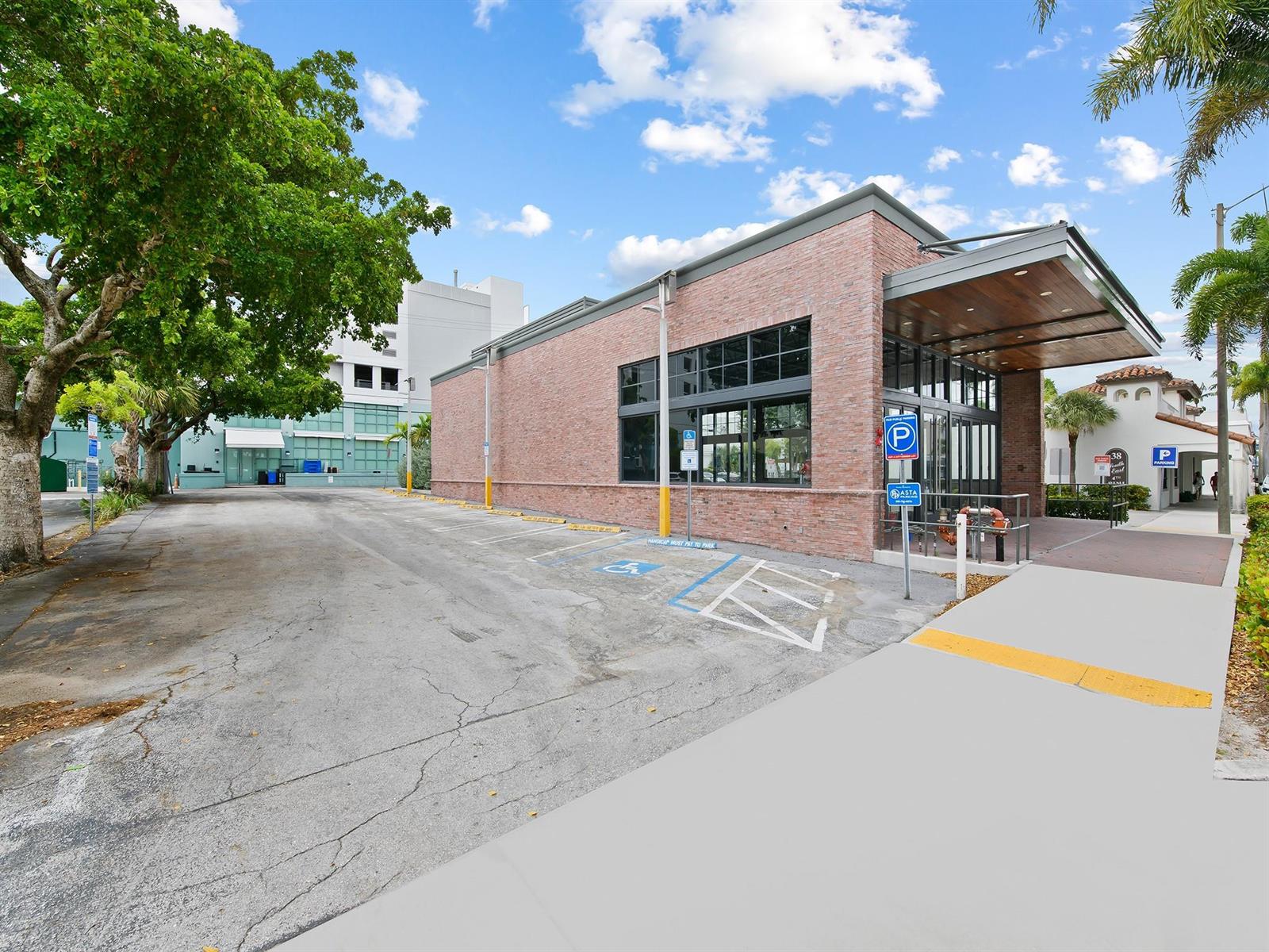 A brick commercial building features a covered entrance and an adjacent paved parking lot — 50 SE 4th Avenue, Delray Beach FL 33483, DELRAY BEACH, FL