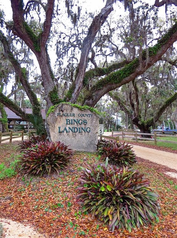 A stone sign for Bings Landing sits beneath large oak trees in a park setting — 17 SHADY LANE N, PALM COAST, FL