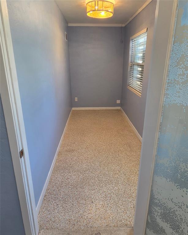 A narrow room with light blue walls, a speckled floor, and a ceiling light fixture — 921 RIDGEWOOD AVENUE UNIT A, HOLLY HILL, FL