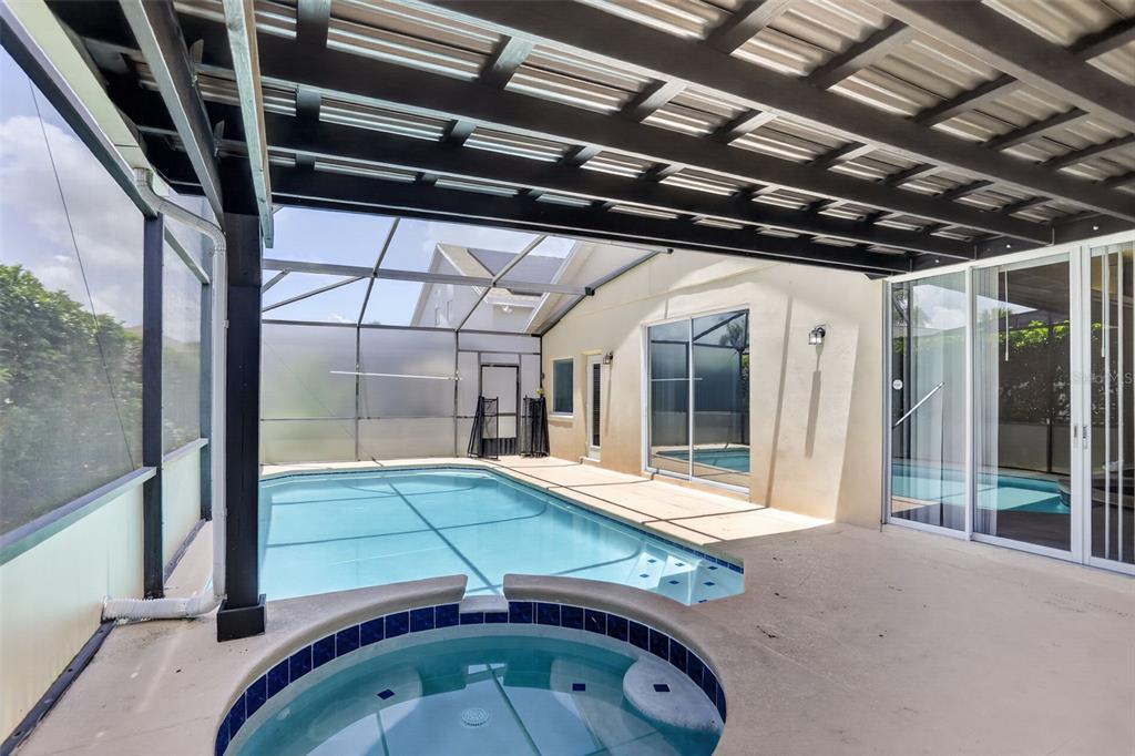 A covered patio features a swimming pool, a circular hot tub, and a screened enclosure — 1844 MORNING STAR DRIVE, CLERMONT, FL