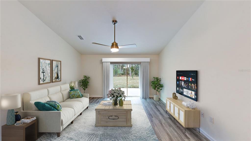 This living room features a white sofa, a wooden coffee table, and a wall-mounted television — 2816 TRICO ROAD, NORTH PORT, FL