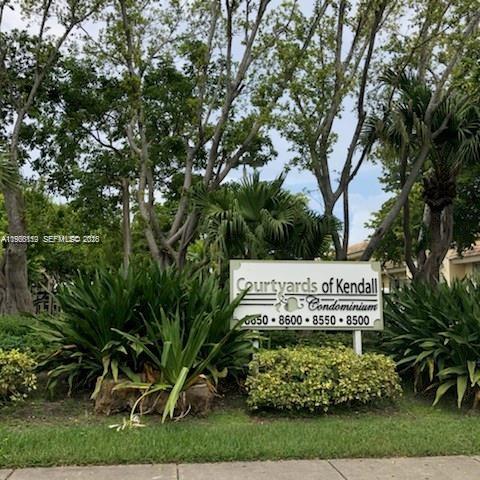 A sign for the Courtyards of Kendall Condominium stands in a garden with trees — 8500 SW 109 Ave # 102, Miami FL 33173, MIAMI, FL