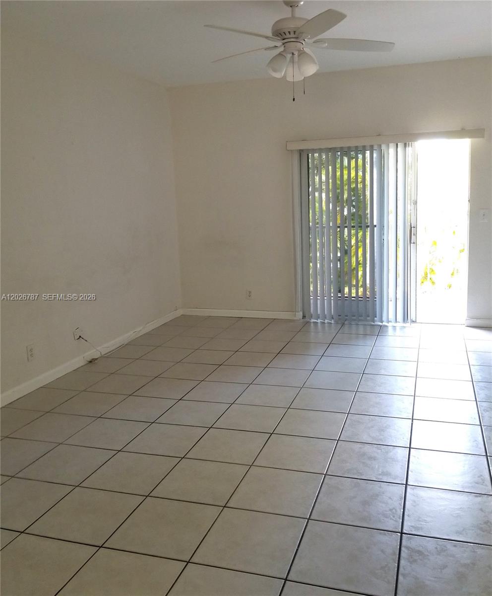 An empty room with light-colored tile flooring, white walls, and a single white door — 4812 Washington St # 147, Hollywood FL 33021, HOLLYWOOD, FL