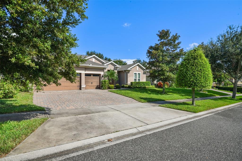 A single-story house with a paved driveway, two-car garage, and a manicured front lawn — 410 SAUVIGNON WAY, GROVELAND, FL