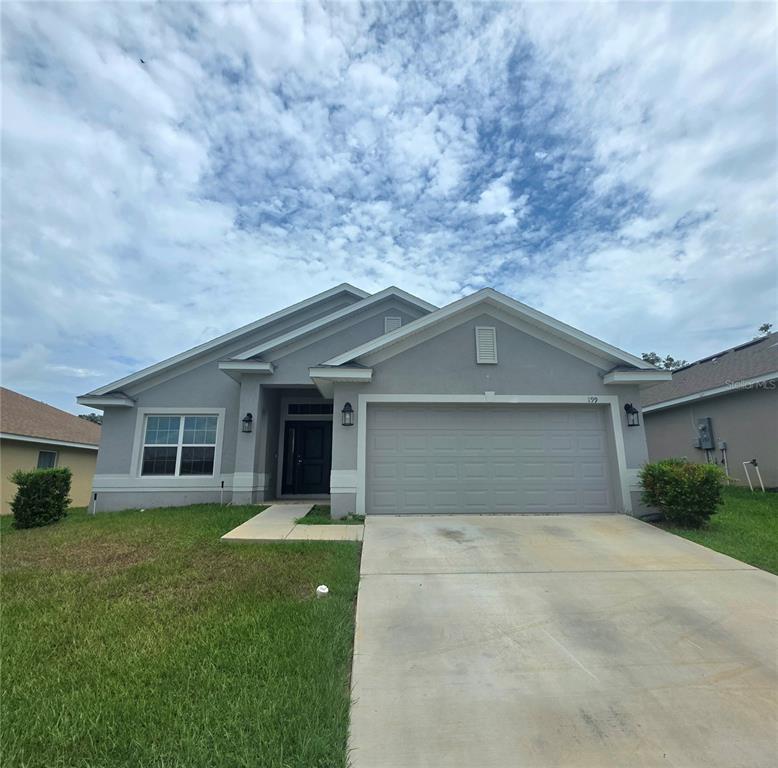 A single-story gray house with a two-car garage and a concrete driveway — 199 NW 45TH LOOP, OCALA, FL