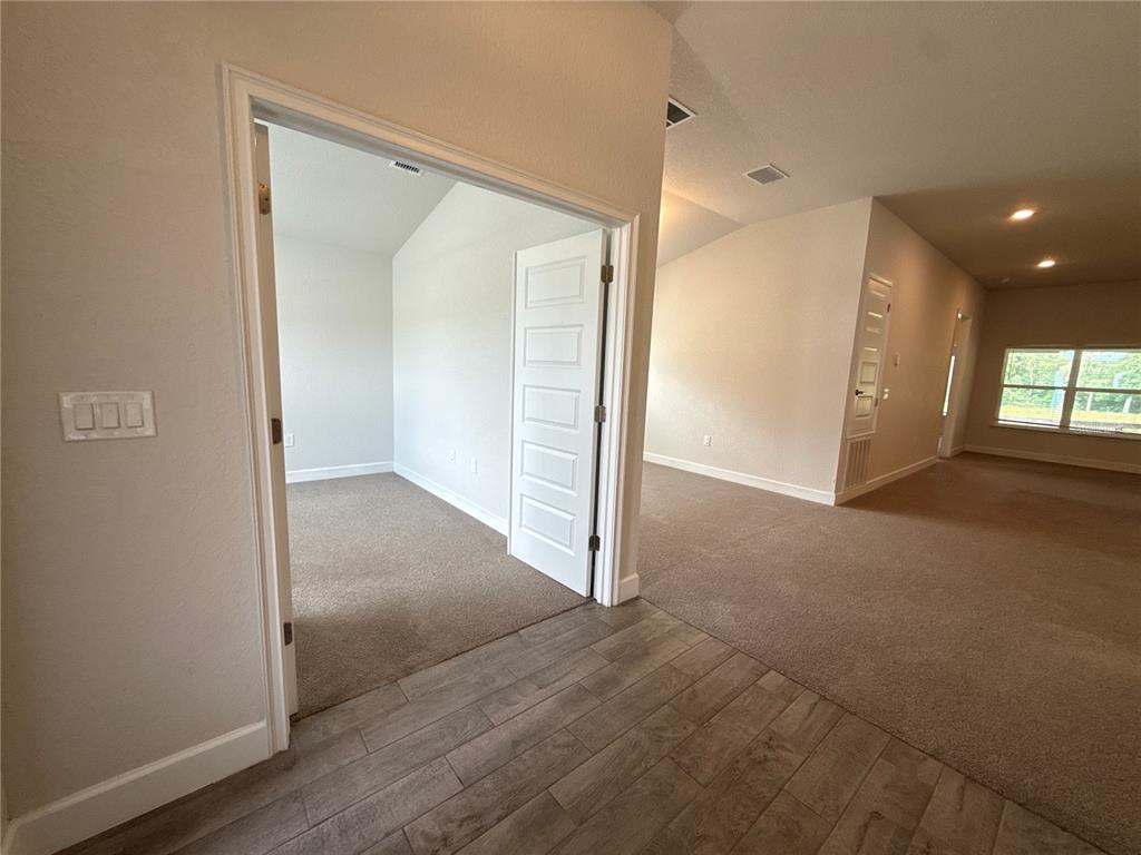 An interior view shows a carpeted room through an open door, adjacent to a tiled hallway — 199 NW 45TH LOOP, OCALA, FL