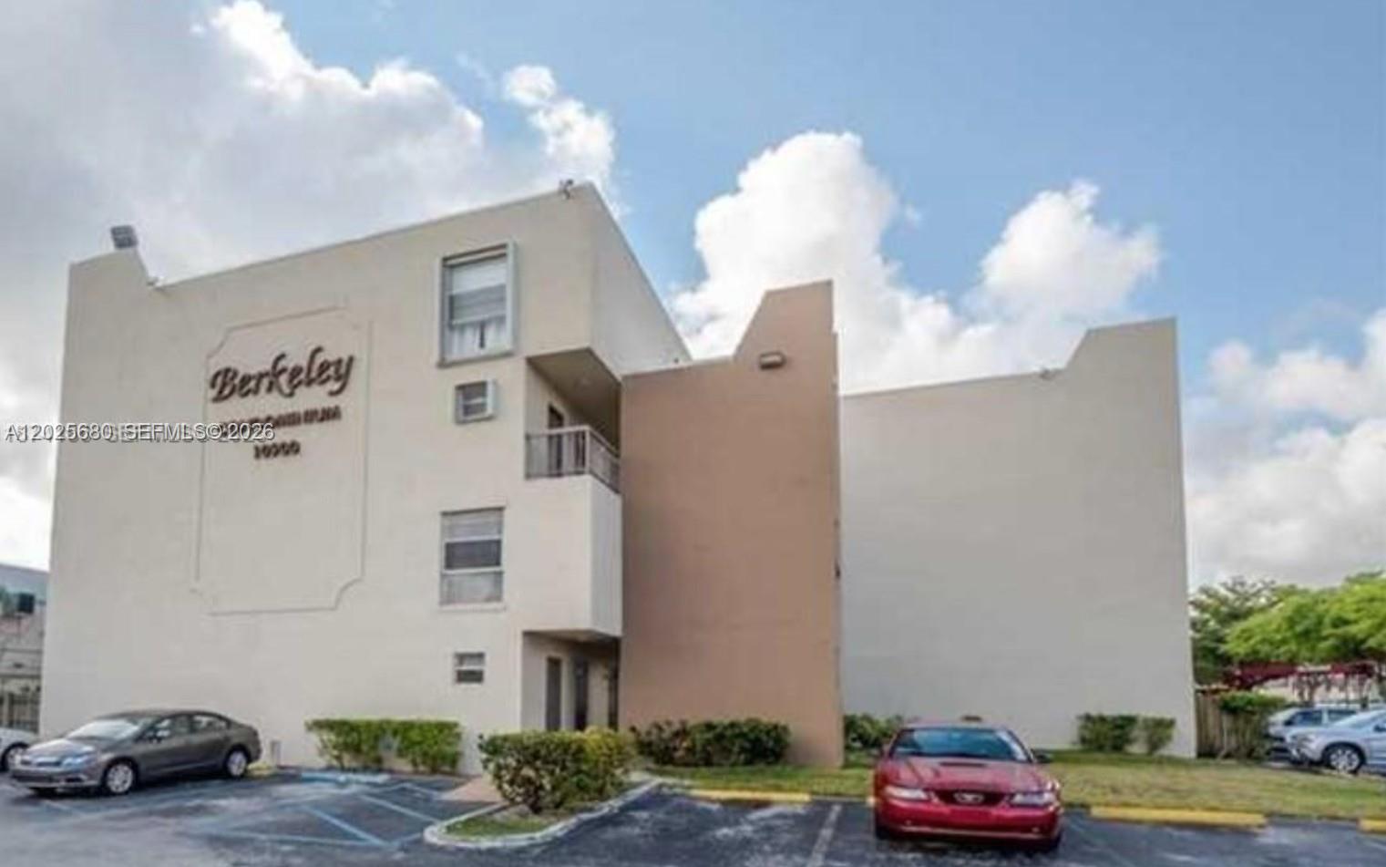 A low-rise apartment building with a beige facade and a parking lot in front — 10900 SW 104th St # 210, Miami FL 33176, MIAMI, FL