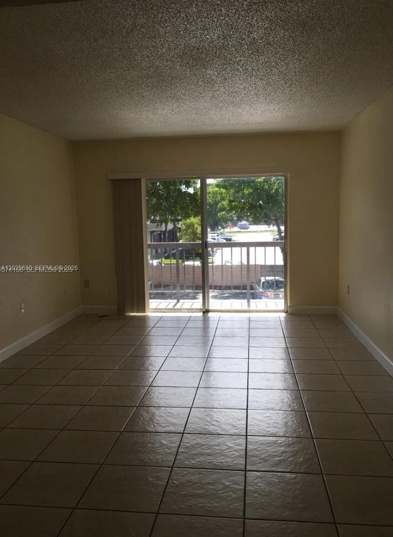 A kitchen features white cabinets, stainless steel appliances, a sink, and light-colored tile flooring — 10900 SW 104th St # 210, Miami FL 33176, MIAMI, FL