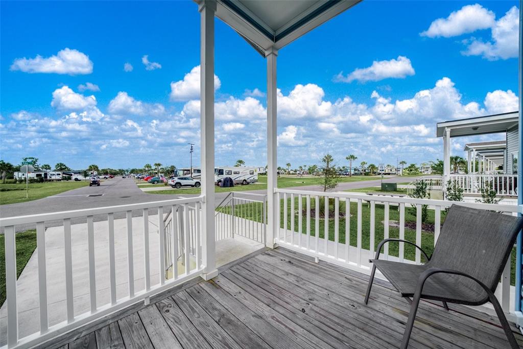 A wooden porch with a white railing overlooks a paved street and parked recreational vehicles — 0 HIGHWAY 630 E UNIT 329, LAKE WALES, FL