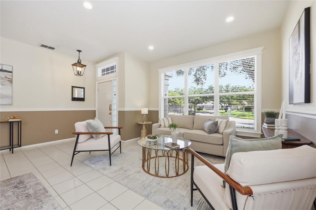 A bright living room features tile floors, a beige sofa, two armchairs, and large windows — 107 GOLDEN CREST COURT, WINTER SPRINGS, FL
