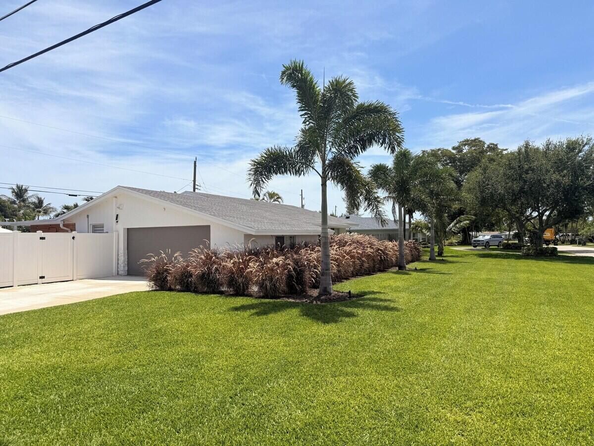 A white house with a gray roof, a garage, and palm trees in the front yard — 541 Ibis Drive, Delray Beach FL 33444, DELRAY BEACH, FL