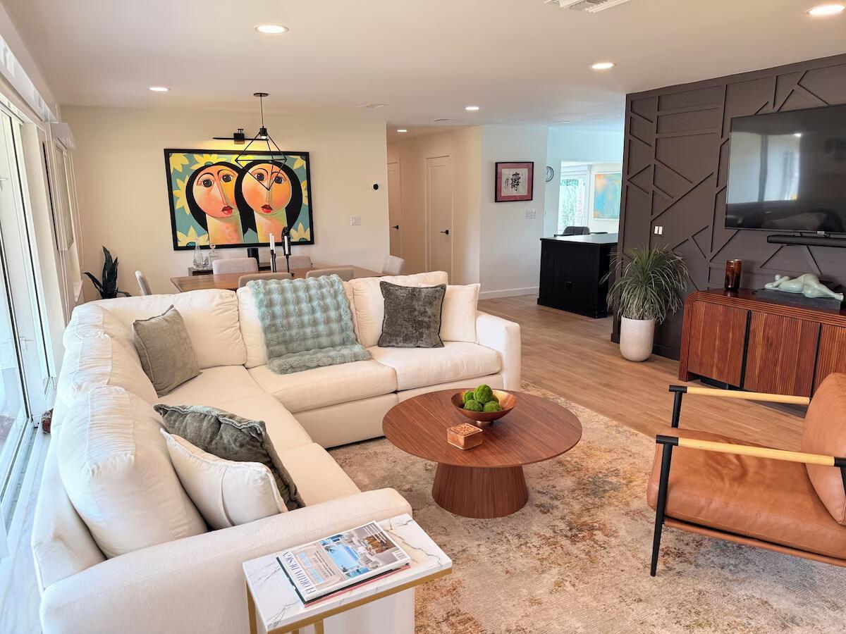A living room features a white sectional sofa, round wood coffee table, and dark accent wall — 541 Ibis Drive, Delray Beach FL 33444, DELRAY BEACH, FL