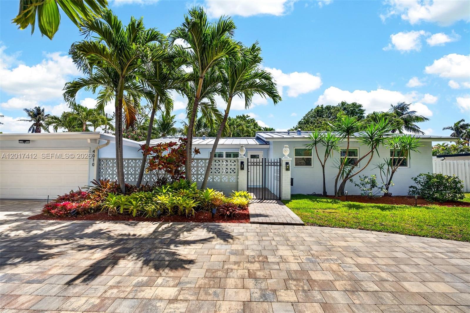 A single-story house with a paved driveway, palm trees, and a gated front courtyard — 4010 NE 22nd Ave, Lighthouse Point FL 33064, LIGHTHOUSE POINT, FL