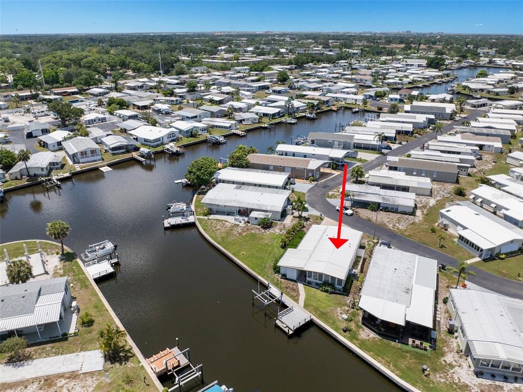 An aerial view shows a waterfront mobile home with a private dock and red arrow — 6806 MOUNT QUINCY DRIVE NE UNIT 361, ST PETERSBURG, FL