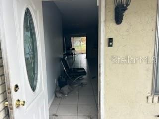 An open white front door reveals a tiled entryway leading to a living area — 365 S NARANJA AVENUE, PORT ST LUCIE, FL