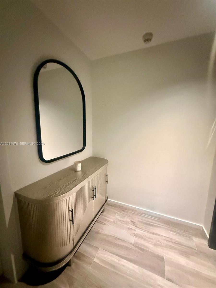 A modern entryway features a light wood console table, a black-framed mirror, and light flooring — 801 S Miami Ave # 3005, Miami FL 33130, MIAMI, FL