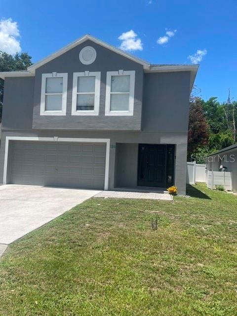 A two-story gray house features a front-facing garage and a dark-colored entry door — 114 GLEASON COVE, SANFORD, FL