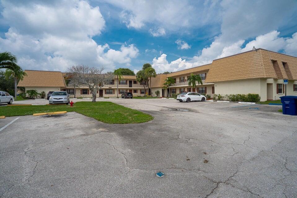 A two-story apartment building with a tan mansard roof and a large paved parking lot — 4151 Oak Terrace Drive # 4151, FL 33463, FL