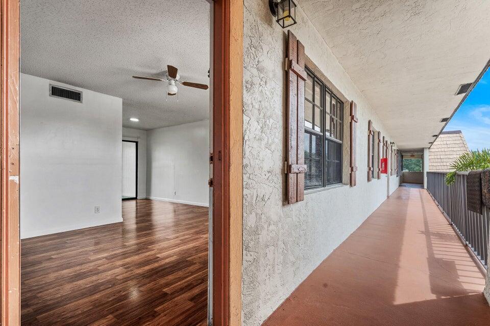 A view from an exterior walkway looking into a room with wood-look flooring — 4151 Oak Terrace Drive # 4151, FL 33463, FL