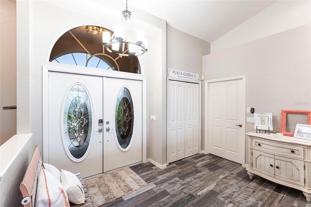 An entryway features double front doors, a chandelier, a closet, and wood-look tile flooring — 1503 SUZI STREET, PUNTA GORDA, FL