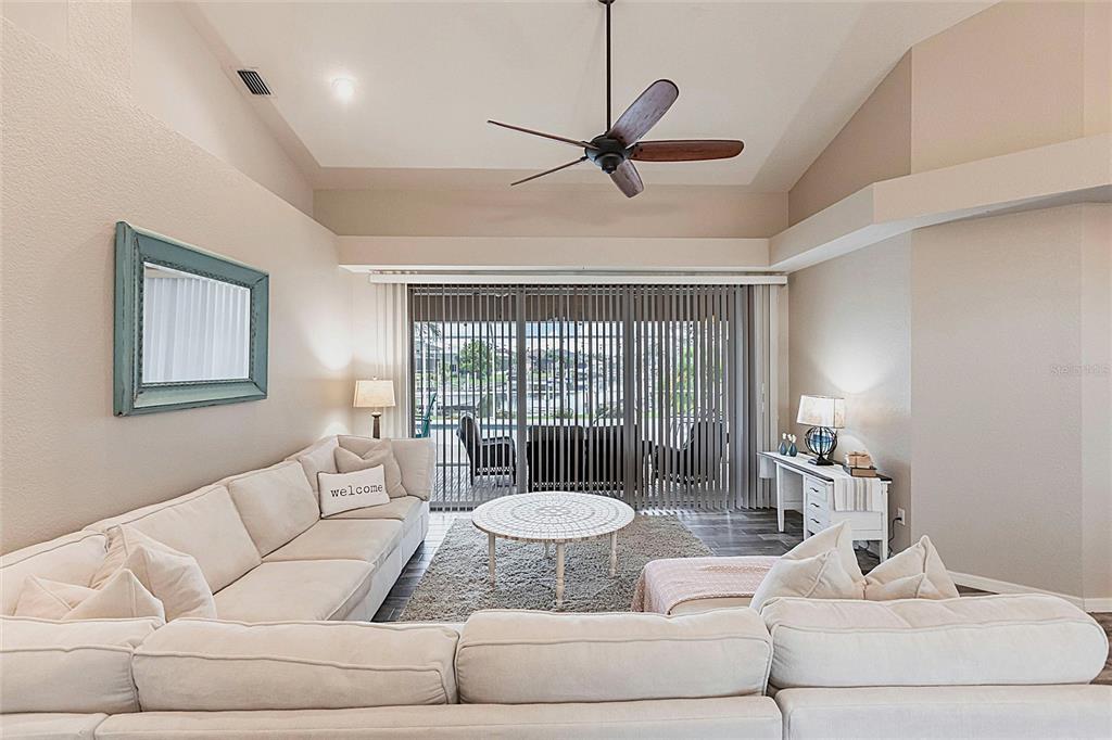 A living room features a large sectional sofa, a ceiling fan, and sliding glass doors — 1503 SUZI STREET, PUNTA GORDA, FL