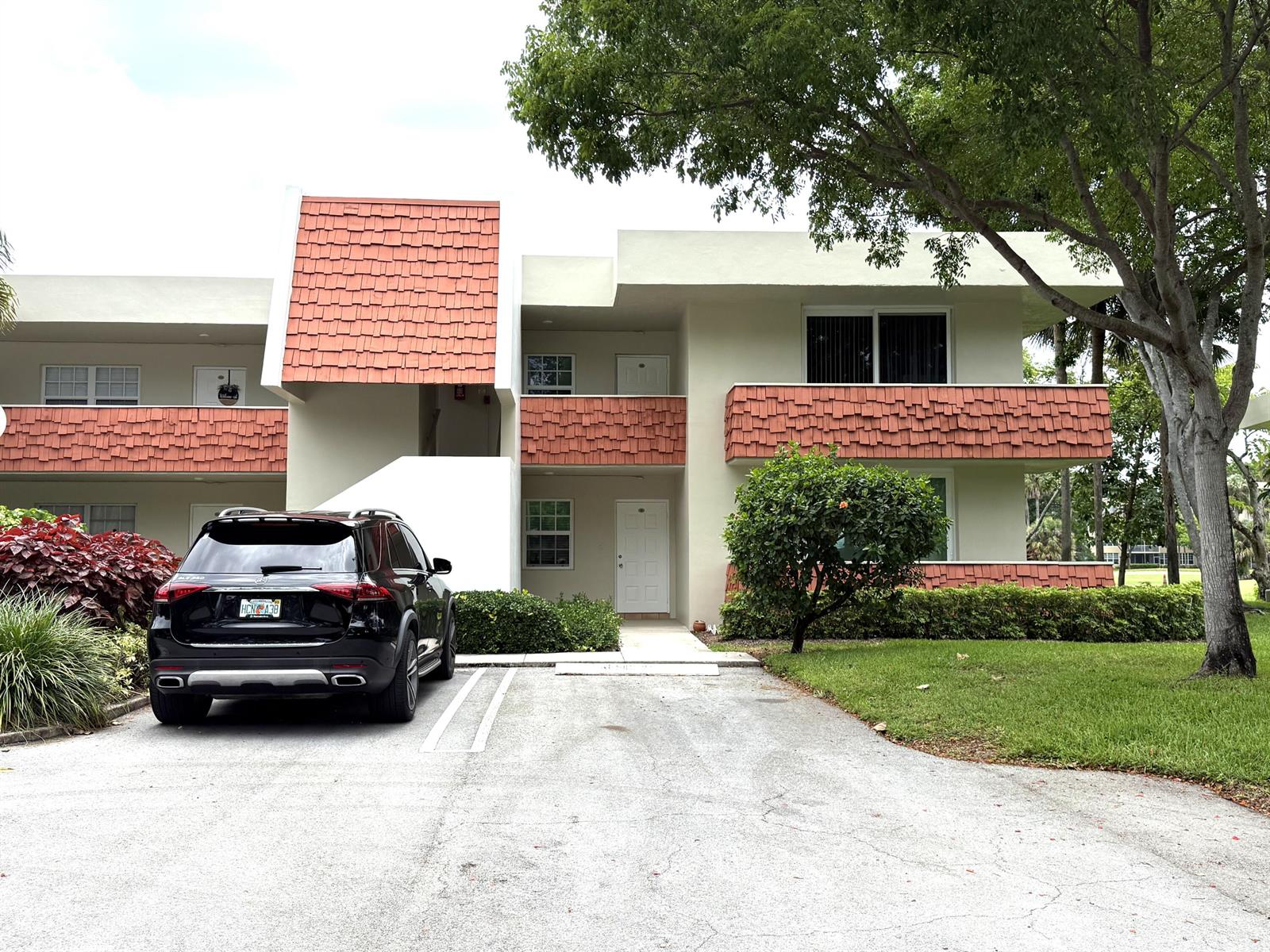 A two-story apartment building features a black SUV parked in front of the entrance — 907 Cypress Terrace # 201, Pompano Beach FL 33069, POMPANO BEACH, FL
