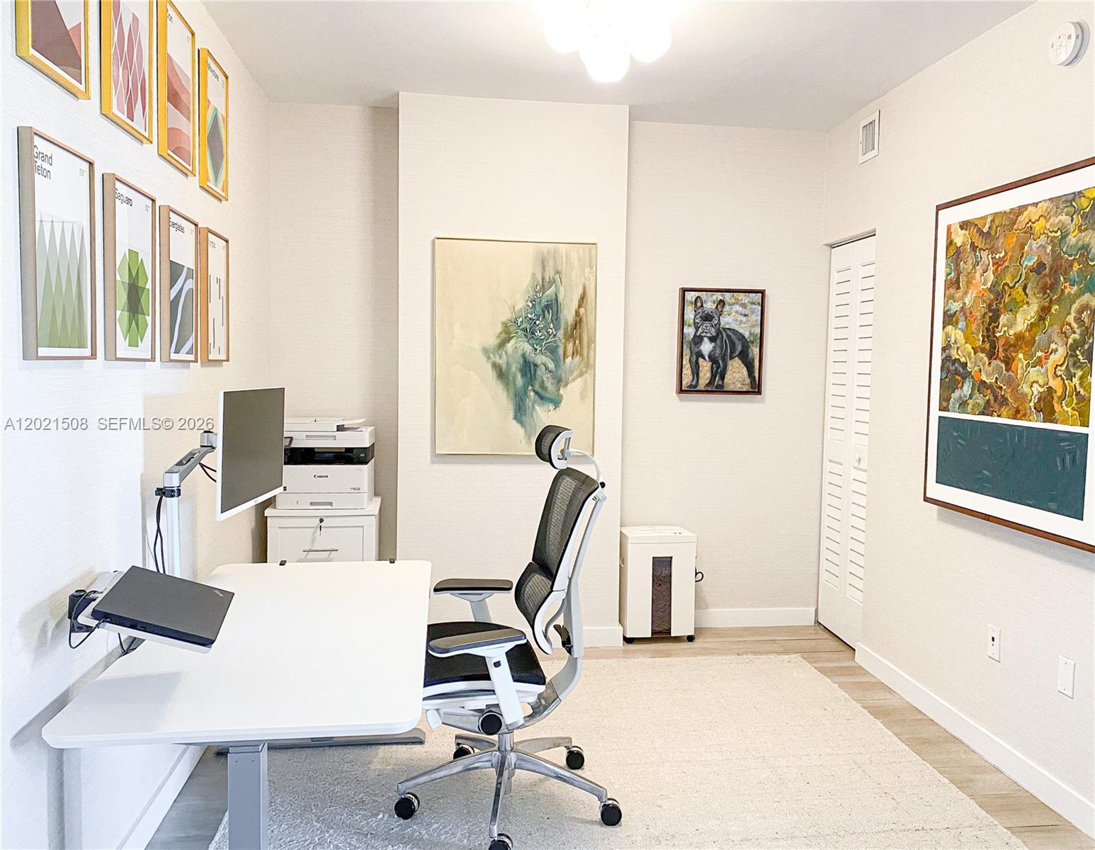 A home office features a white desk, ergonomic chair, wall art, and a printer — 1600 SW 1 AVE # 515, Miami FL 33129, MIAMI, FL