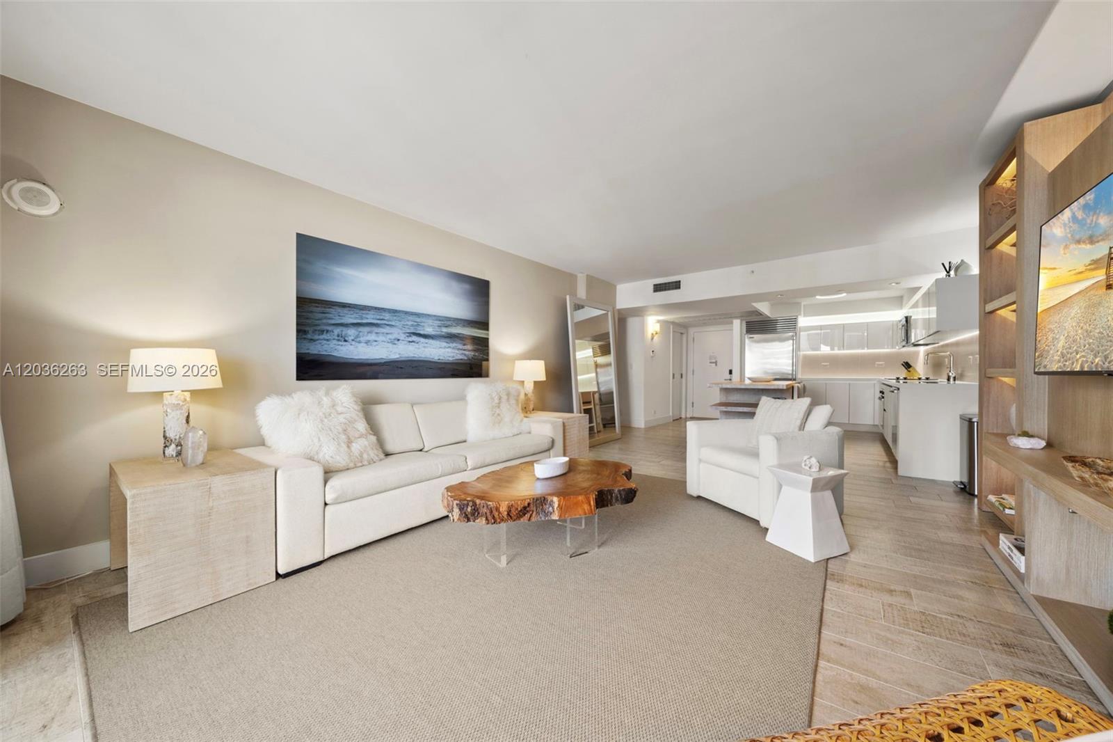 A living room features a white sofa, a live-edge coffee table, and an open kitchen — 102 24th St # 1210, Miami Beach FL 33139, MIAMI BEACH, FL