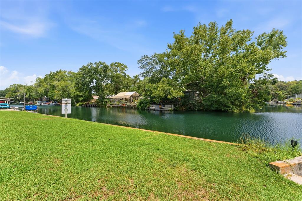 A light green house with a stone walkway leading to a dark blue front door — 6355 SEBRING STREET, WEEKI WACHEE, FL