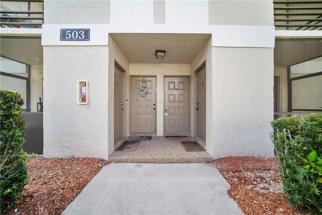 The exterior entrance of a building shows two adjacent doors under a covered porch — 503 Gardens Drive # 202, Pompano Beach FL 33069, POMPANO BEACH, FL