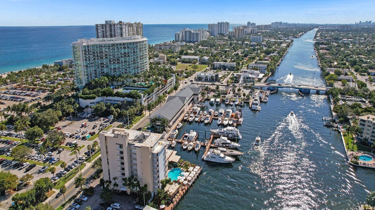An aerial view shows a coastal high-rise building, a marina with docked boats, and a canal — 1 N Ocean Boulevard # 903, Pompano Beach FL 33062, POMPANO BEACH, FL