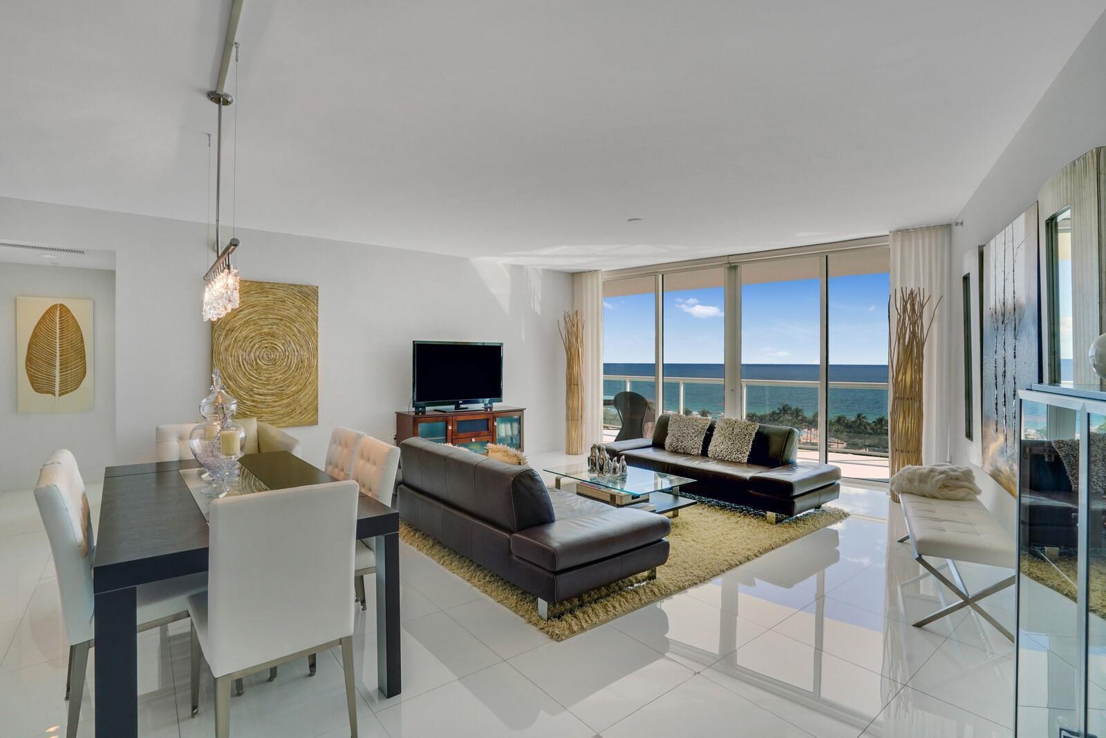A modern living and dining room with white tile floors and a view of the ocean — 1 N Ocean Boulevard # 903, Pompano Beach FL 33062, POMPANO BEACH, FL